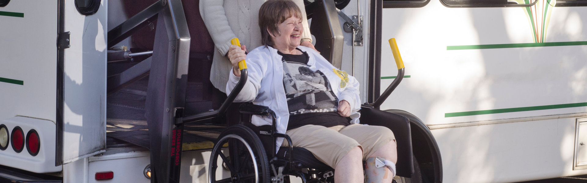 Elderly woman with her caregiver about to get off the vehicle