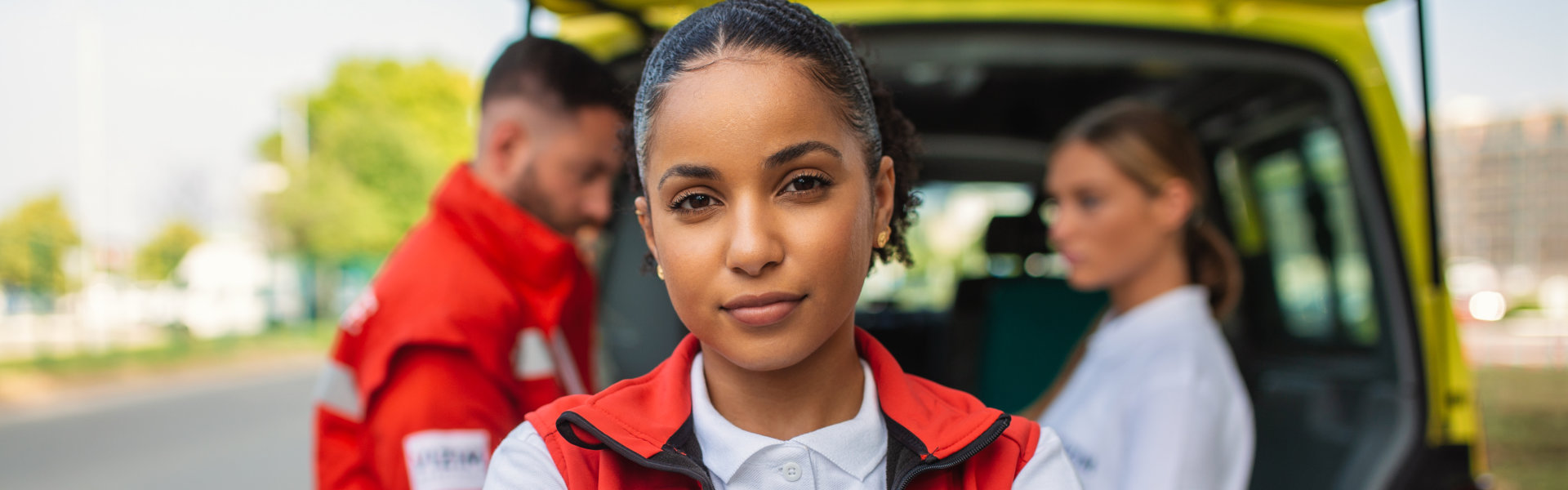 Woman paramedic standing rear of the vehicle