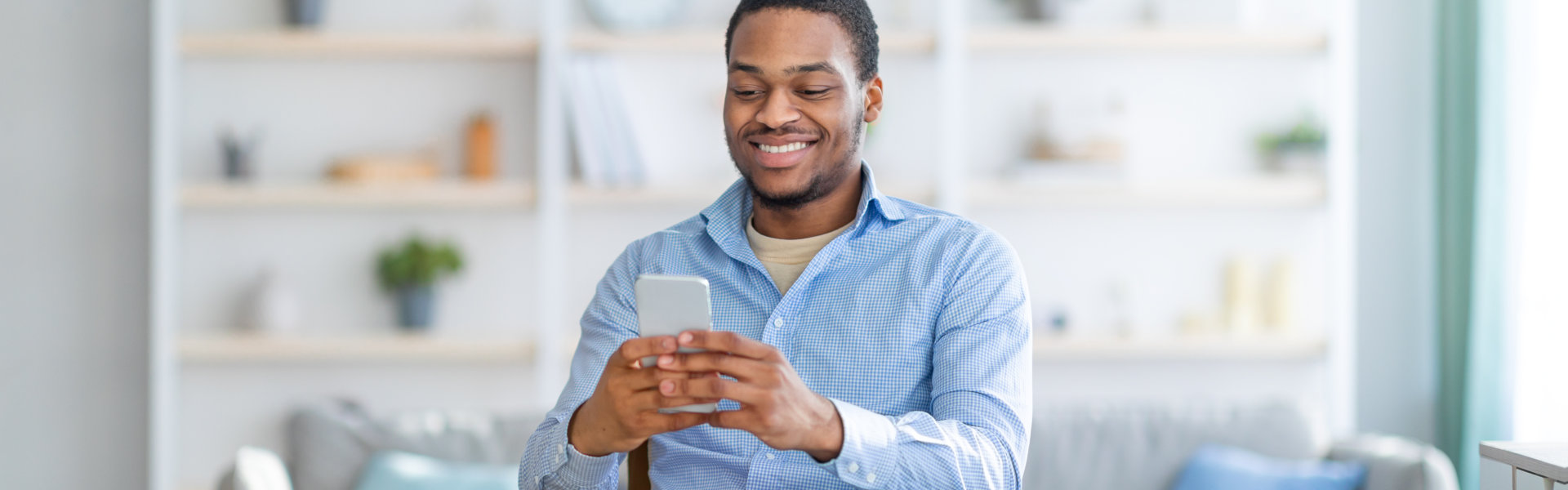 Man smiling while using his phone